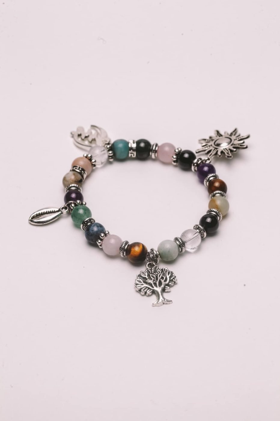 Beaded charm bracelet with silver sun, tree and cowrie charms