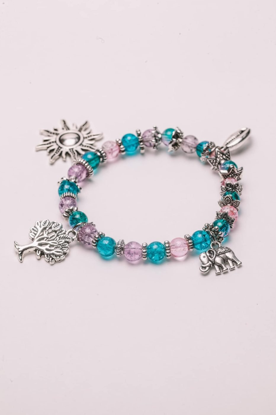 Beaded charm bracelet with silver sun, tree and cowrie charms