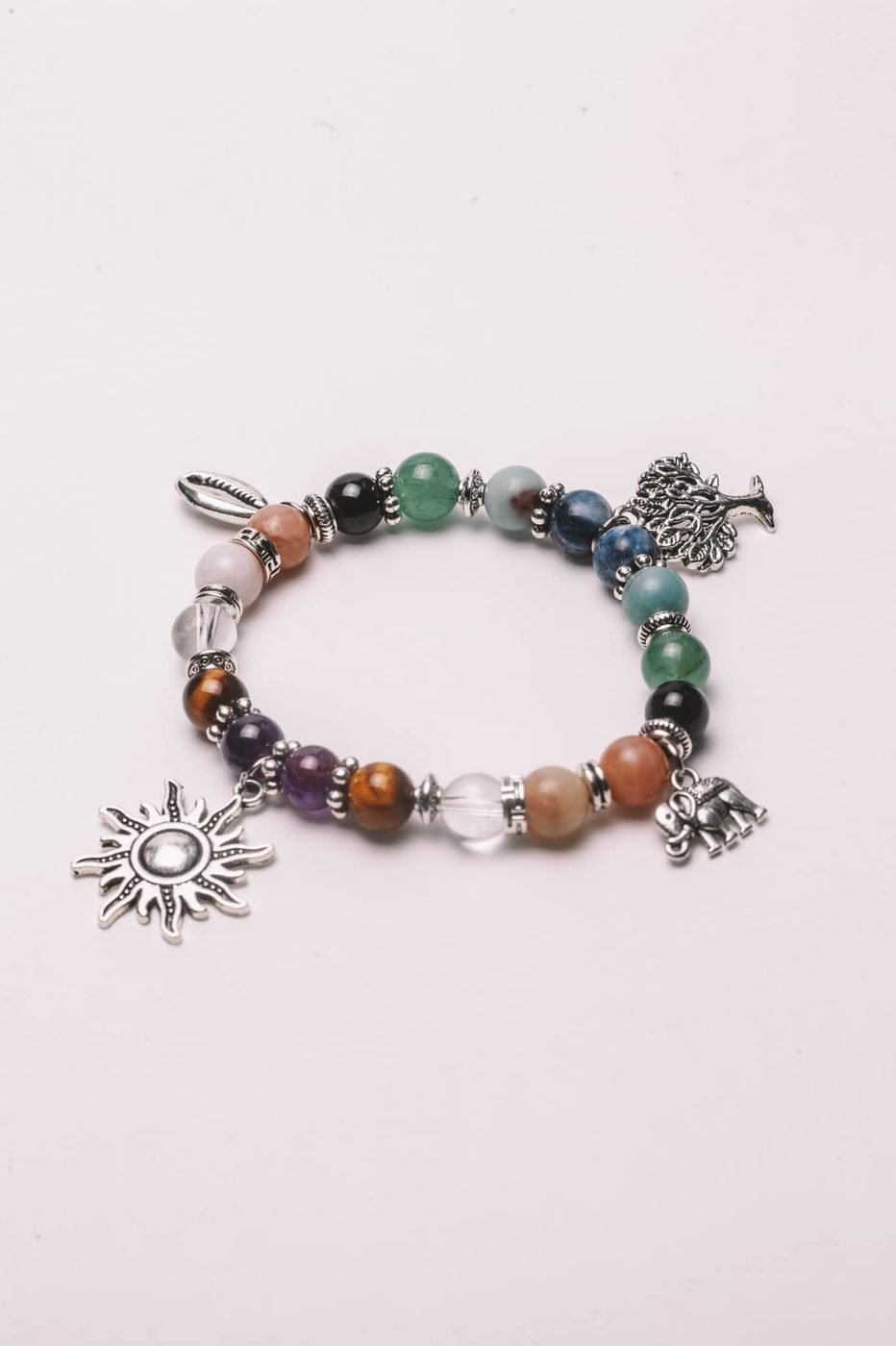 Beaded charm bracelet with silver sun, tree and cowrie charms